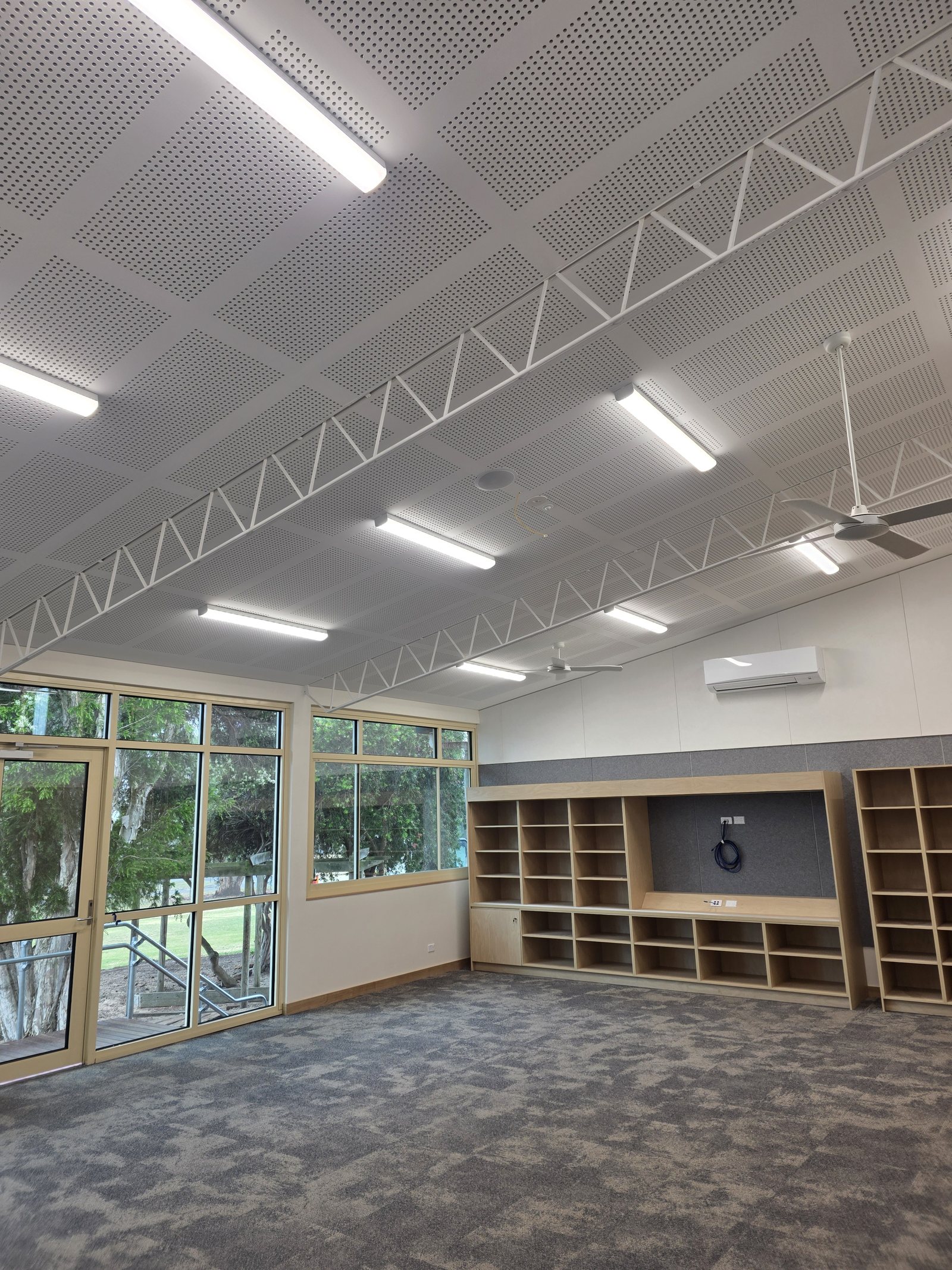 Hall with linear suspended lighting and acoustic ceiling